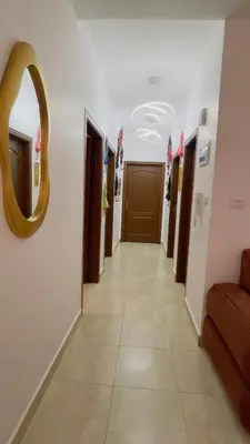 a hallway with a mirror on the wall and a door at شقة مفروشة في طبربور in Amman