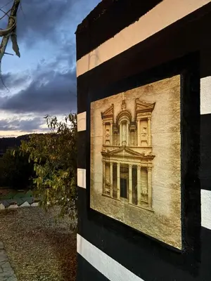 a painting of a building on the side of a building at petra towering rock in Wadi Musa