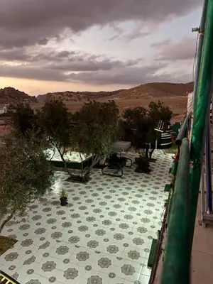 a view of a balcony with a patio with trees at petra towering rock in Wadi Musa