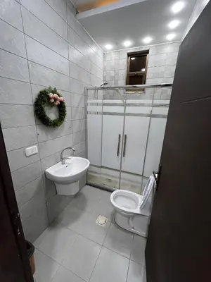 a bathroom with a toilet and a sink at Al Zain Chalet - Private Pool in Al Kafrayn