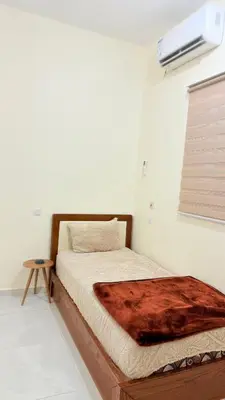a bed with a wooden frame in a room at هوستل خدمه مبيت in Disah