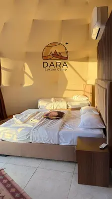 two beds in a room with a sign on the wall at DARA RUM lUXURY CAMP in Wadi Rum