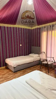 two beds in a room with a purple canopy at DARA RUM lUXURY CAMP in Wadi Rum