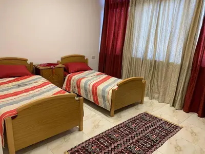 a bedroom with two beds and a rug at City View Rooftop Apartment Amman in Amman