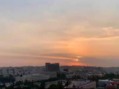 a view of a city with the sunset in the sky at City View Rooftop Apartment Amman in Amman