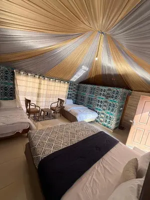 a bedroom with two beds in a tent at NAJMA lUXURY CAMP in Wadi Rum