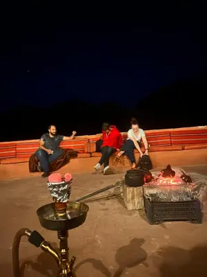 a group of people sitting around a campfire at night at Fire bedouin camp in Wadi Rum