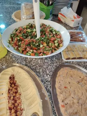 a table topped with plates of food and pies at Petra Bed Hostel in Petra