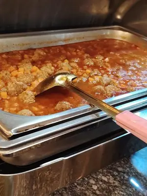 a wooden spoon in a dish of food in an oven at Petra Bed Hostel in Petra