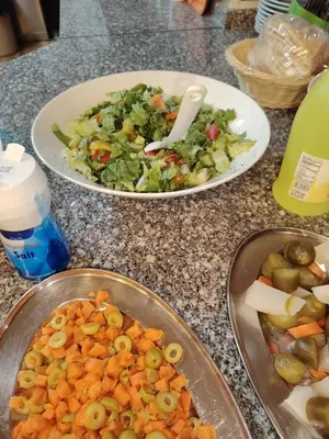 a table with two plates of food and a salad at Petra Bed Hostel in Petra