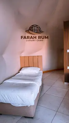 a bed in a room with a sign on the wall at FARAH RUM LUXURY CAMP & Bubbles Hotel in Wadi Rum