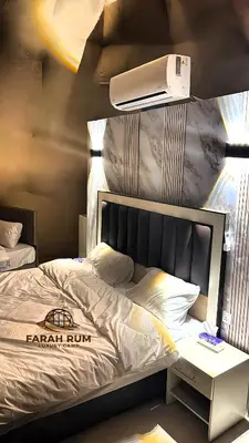 a bedroom with a bed with a nightstand next to it at FARAH RUM LUXURY CAMP & Bubbles Hotel in Wadi Rum