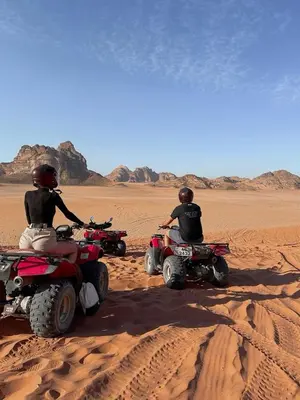 two people are riding atvs in the desert at Silent Sands Lodge in Disah