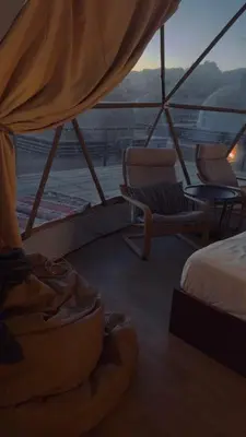 a room with a bed and chairs on a boat at Silent Sands Lodge in Disah