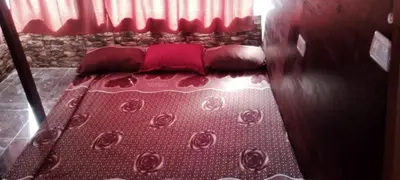 a bed with red pillows on it in a room at Petra sharing room in Petra