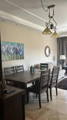 a dining room with a wooden table and chairs at Luxury Apartment for Daily Rent in Shmaisani in Amman