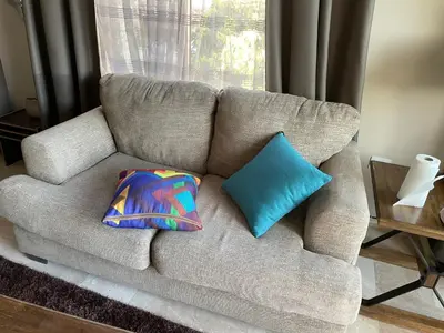 a couch with two pillows on it in a living room at Luxury Apartment for Daily Rent in Shmaisani in Amman