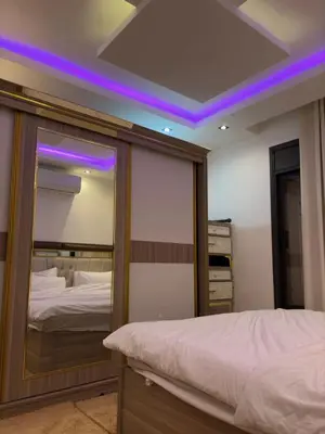 a bedroom with a mirror and a bed at شقة عصرية 2025 غرف نوم 2, غرفة معيشة, مطبخ كامل, فرش راقي جدا في الشميساني قرب المستشفى التخصصي in Amman