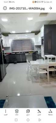 a kitchen with a table and chairs in a room at Al qaoud apartment in Aydūn