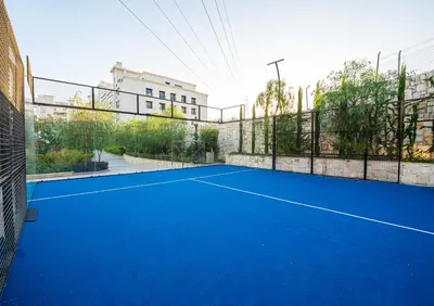 a blue tennis court with a fence at كمباوند شقة مفروشة كومباوند الامعري المطار 222 in Amman