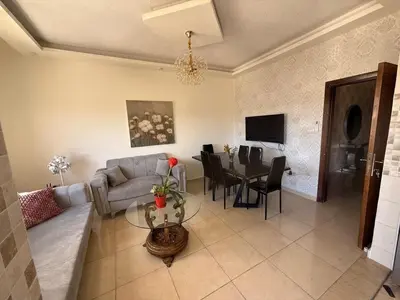 a living room with a couch and a table at Furnished luxuries Apartment with a Stunning View in Amman