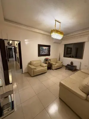 a large living room with couches and a chandelier at Furnished luxuries Apartment with a Stunning View in Amman