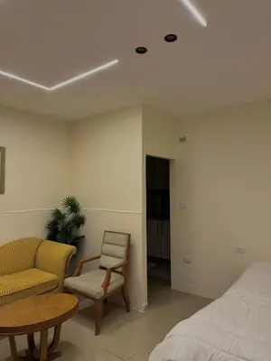 a bedroom with a bed and a couch and a table at The cava in Amman