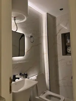 a white bathroom with a sink and a toilet at The cava in Amman