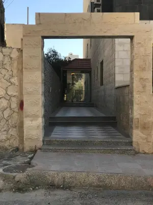 an entrance to a building with a stone wall at Fully Furnished apartment for rent in Amman Khalda in Amman