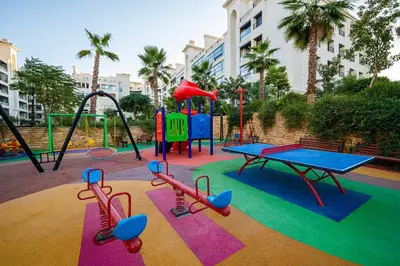 a playground with a ping pong table and slides at طريق المطار بوليفارد الامعري in Amman
