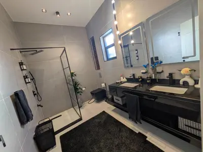 a bathroom with a sink and a shower and a mirror at Noorhan Private Luxury Layover Villa - 10 Minutes to Airport in Amman