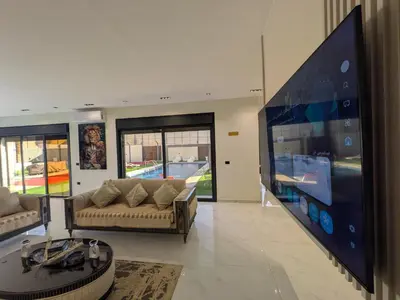 a living room with a large flat screen tv at Noorhan Private Luxury Layover Villa - 10 Minutes to Airport in Amman