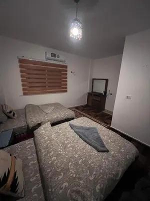 a bedroom with two beds and a pendant light at Peace House in Wadi Musa