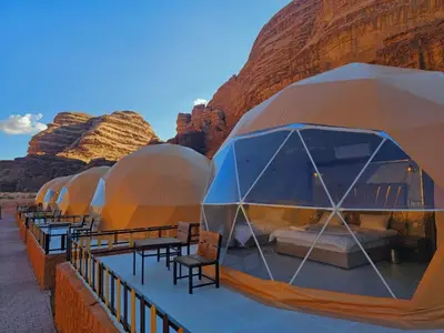 a row of domes with tables and chairs in the desert at Lunar scape haven in Wadi Rum