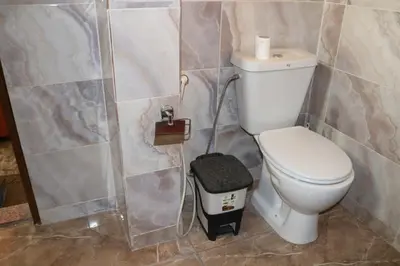a bathroom with a toilet and a trash can at Premium apartment Section A in Wadi Musa