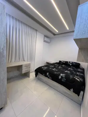 a bedroom with a black bed and a table at Nice place in Irbid