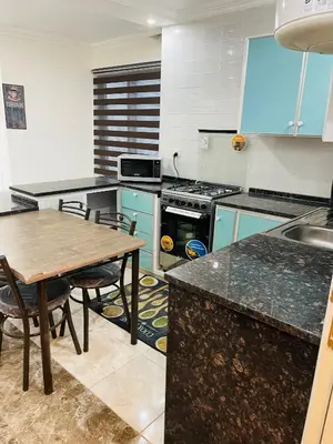 a kitchen with blue cabinets and a wooden table at New studio in Jabal Amman and Al-Weibdeh متابعة in Amman
