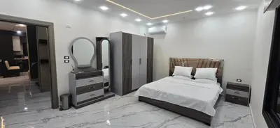 a bedroom with a bed and a mirror and a dresser at شاليه المهرة in Murayjimat Ibn Ḩāmid