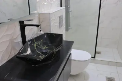 a bathroom with a black sink and a toilet at شاليه المهرة in Murayjimat Ibn Ḩāmid