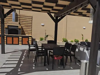 a patio with a table and chairs and a fireplace at شاليه المهرة in Murayjimat Ibn Ḩāmid