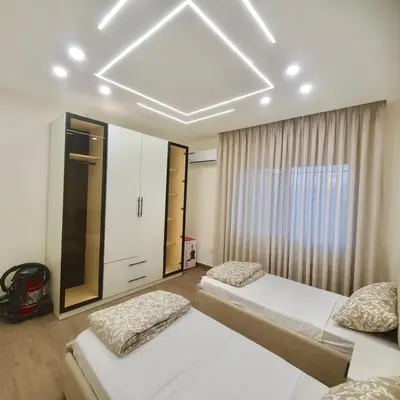 a bedroom with two beds and a large ceiling at Cozy 3BR Apartment by 7th Circle in Amman