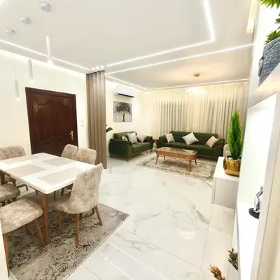 a living room with a table and chairs at Cozy 3BR Apartment by 7th Circle in Amman