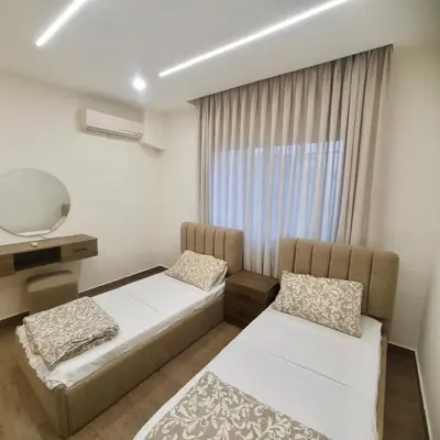 a bedroom with two beds and a mirror and a window at Cozy 3BR Apartment by 7th Circle in Amman