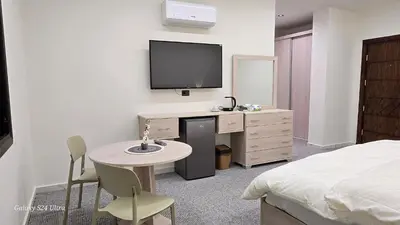 a bedroom with a bed and a desk with a tv at Jeeso Hotel in Jerash