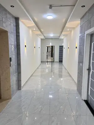 a hallway with white walls and a tile floor at Zurich Furnished Apartments in Al Mafraq