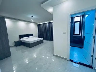 a bedroom with a bed in the middle of a room at Zurich Furnished Apartments in Al Mafraq