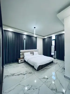 a bedroom with a bed and a marble floor at Zurich Furnished Apartments in Al Mafraq