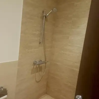 a shower with a shower head in a bathroom at Family WeekEnds Getaways at Samarah Resort Studio in Sowayma