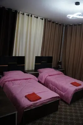two beds in a room with pink sheets at Petra entrance Apartment in Petra
