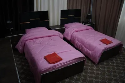 two beds in a room with pink blankets at Petra Visitor Center Apartment in Petra